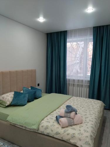a bedroom with a large bed with blue pillows at Абая in Temirtaū