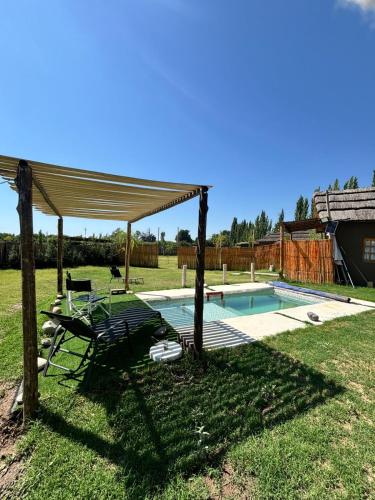 a pavilion with a table and a chair next to a pool at Cabanas Embau in San Rafael