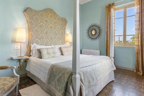a bedroom with a large bed and a mirror at Fontelunga Hotel & Villas in Pozzo
