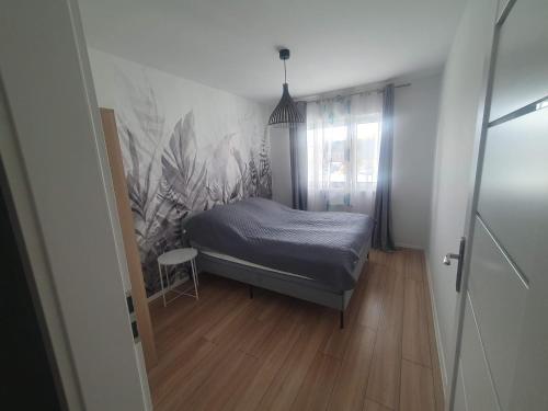 a small bedroom with a bed and a window at Apartament Number One NOVA WOZOWNIA in Leszno