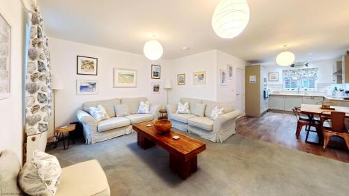 a living room with a couch and a table at The Tidal Shack - Part of the The Bay Filey Holiday Village with pool, gym and direct beach access, pub, restaurant, tennis and meadows walks in Reighton