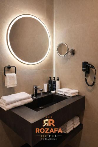 een badkamer met een wastafel en een spiegel bij Hotel Rozafa in Suharekë