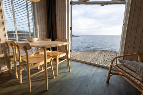 a table and chairs in a room with a view of the ocean at Brouwersdam Stay in Ouddorp