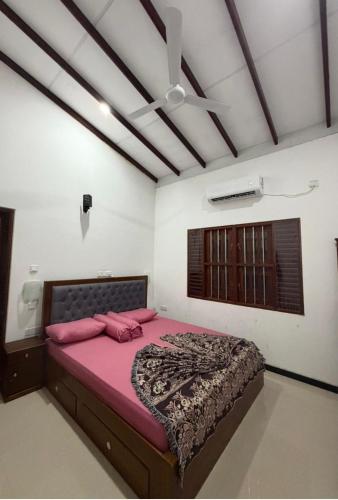 a bedroom with a pink bed in a room at Orkid villa in Hikkaduwa