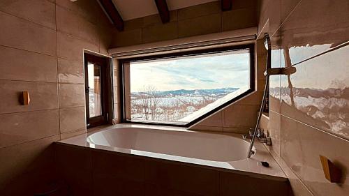 a bath tub in a bathroom with a window at Mountain View Retreat Mionica in Kosjeric