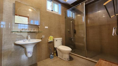 a bathroom with a toilet and a sink and a shower at Dongle B&B in Taitung City