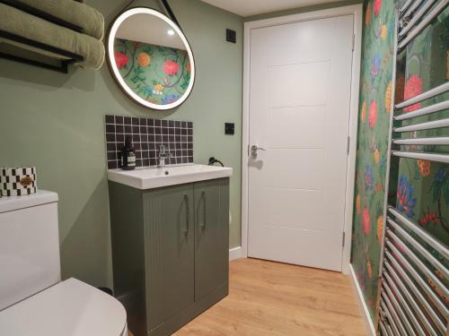 a bathroom with a sink and a mirror and a toilet at The Corn Silo in Ipswich