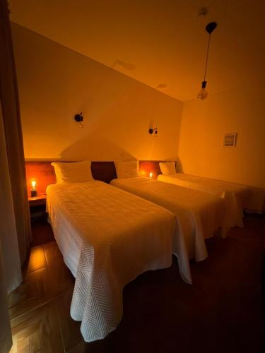 two beds in a hotel room with two lamps at Romeu in Quarteira