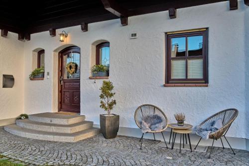 two chairs and a table in front of a house at Ferienwohnung Fritz in Bodenmais