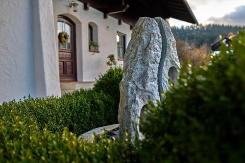 a stone statue in front of a house at Ferienwohnung Fritz in Bodenmais