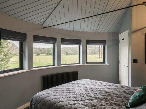 a bedroom with windows and a bed in it at The Barley Silo in Ipswich