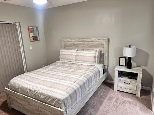 a bedroom with a bed and a night stand with a lamp at Cozy and Modern Vacation Home in Hallandale Beach