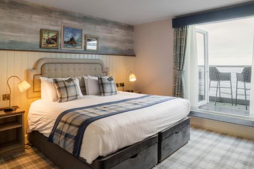 a bedroom with a large bed and a large window at The Bamburgh Castle Inn - The Inn Collection Group in Seahouses