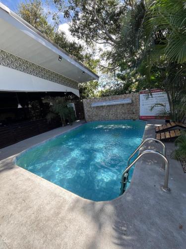 a swimming pool with a slide in a yard at Hotel Wilson Anexo in Liberia
