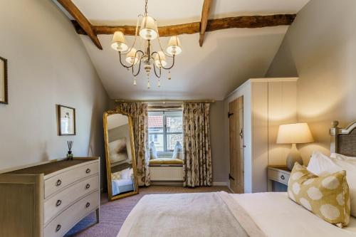 a bedroom with a bed and a dresser and a mirror at Wentbridge House Hotel in Pontefract