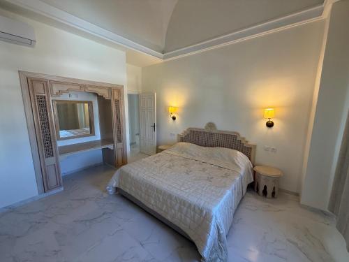 a bedroom with a bed and a tv in it at Yocca Hotel Residence in Hammamet