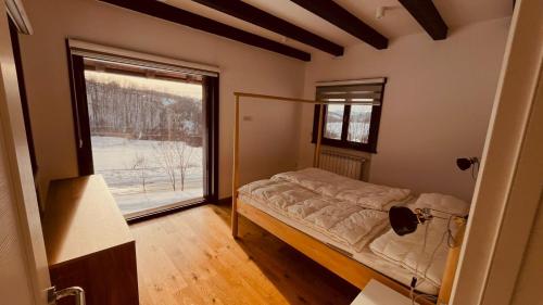 a bedroom with a bed and a large window at Mountain View Retreat Mionica in Kosjeric
