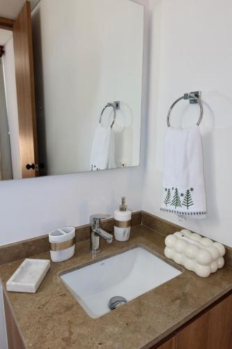 a bathroom counter with a sink and a mirror at Rodadero Ocean View Luxury Apt with Rooftop Pool in Taganga