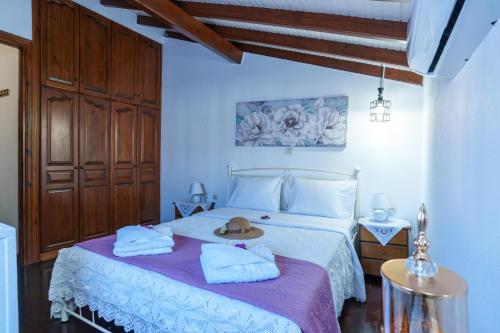 a bedroom with a bed with towels and a hat on it at Zoe House in Sidari