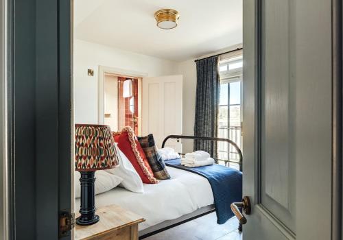 a bedroom with a bed with pillows and a window at Dumbarnie West Cottage in Kirkton of Largo