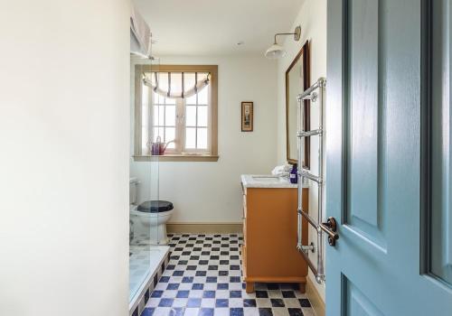 a bathroom with a toilet and a sink and a door at Dumbarnie West Cottage in Kirkton of Largo