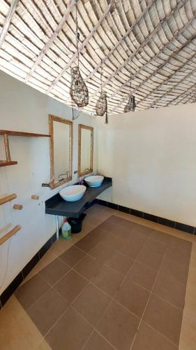 a bathroom with two sinks and two mirrors at Coco Tent Seaview 360 in Ko Lanta
