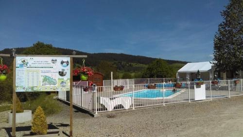 a sign next to a swimming pool with a tent at ZEcamping 3 étoiles dog friendly piscine chauffée en bordure de l'Allier in Lespéron