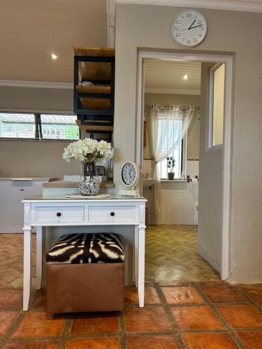 a white desk with a vase of flowers on it at Windkraal Farm Studio in Bonnievale