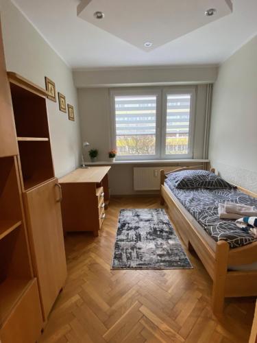 a bedroom with a bed and a desk and a window at Apartament 94 Konin in Konin