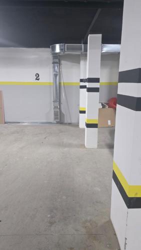 an empty parking garage with white and black stripes at Apartman Nadja in Šabac