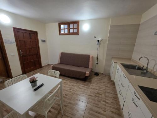 a kitchen with a table and a couch in a room at apartamentos la villa 3 in San Sebastián de la Gomera