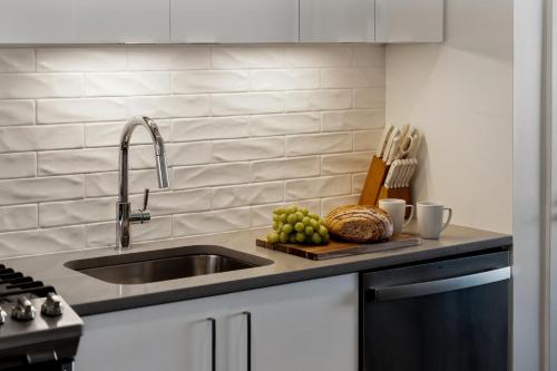 a kitchen counter with a sink and a bowl of fruit at Hyatus Luxury Residences Boston Everett Marquis Collection in Everett