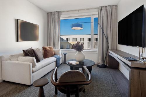 a living room with a couch and a large window at Hyatus Luxury Residences Boston Everett Marquis Collection in Everett