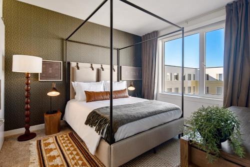 a bedroom with a canopy bed and a window at Hyatus Luxury Residences Boston Everett Marquis Collection in Everett