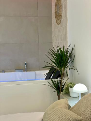 a bathroom with a tub and a plant in it at Romantic Suite & Jungle in Longjumeau