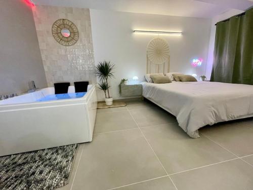 a bedroom with a large bed and a bath tub at Romantic Suite & Jungle in Longjumeau