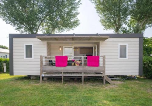 a tiny house with two red chairs on a porch at ZEcamping 3 étoiles animaux acceptés avec piscine chauffée à Guérande in Guérande