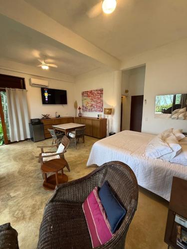 a bedroom with a bed and a couch and a table at Vista para o Mar - Studio com 2 banheiros - Barra do Sahy in São Sebastião