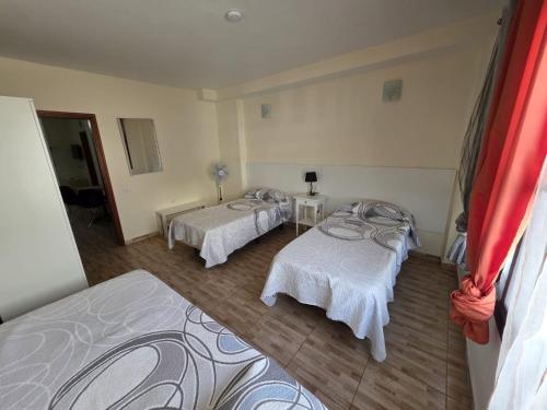 a room with two beds and a mirror at apartamentos la villa 3 in San Sebastián de la Gomera