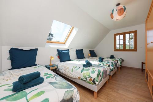 a attic bedroom with two beds and a window at Gîte À la Bonne Compagnie in Preures