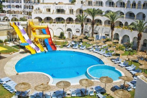 an outdoor swimming pool with a water slide in a resort at Hotel El Habib Monastir in Monastir