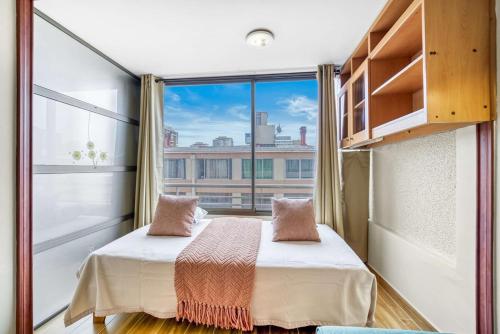 a bedroom with a bed and a large window at Espacio Viña- 1D with Wifi in Viña del Mar
