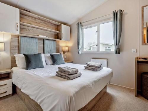 a bedroom with a large white bed with towels on it at 3 Bed in Ventnor oc-94278 in Rookley