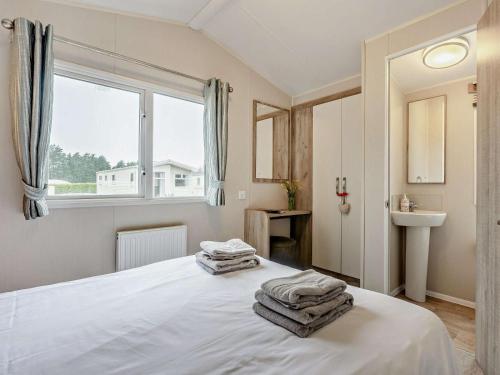 a bedroom with a white bed with towels on it at 3 Bed in Ventnor oc-94278 in Rookley