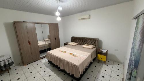 a small bedroom with a bed and a mirror at Casa inteira in Coxim