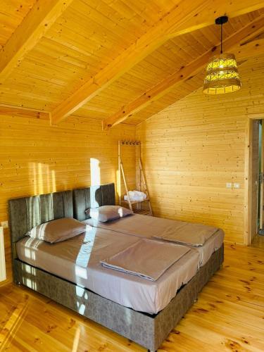 a bedroom with a large bed in a wooden room at Kobuleti Seaside Cottage in Kobuleti