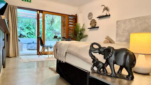 a statue of an elephant and a calf on a bed at LoerieRoep Estate - Mountainview Selfcatering Accommodation Nelspruit in Nelspruit