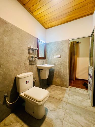 a bathroom with a toilet and a sink at Topical Mangrove Villa in Tangalle