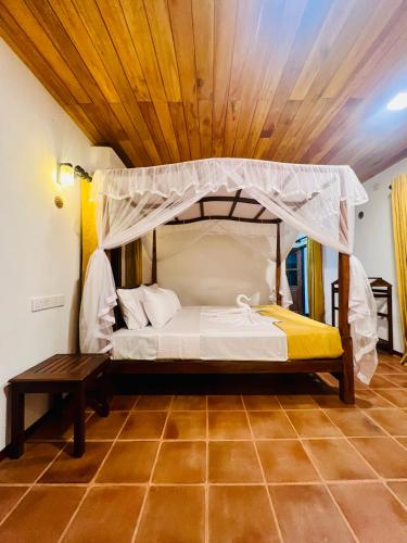 a bedroom with a bed with a canopy at Topical Mangrove Villa in Tangalle