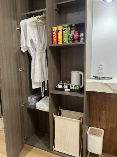 a closet with a sink and a shelf with towels at SMDC Cheer residences-ZKL SUITES in Marilao